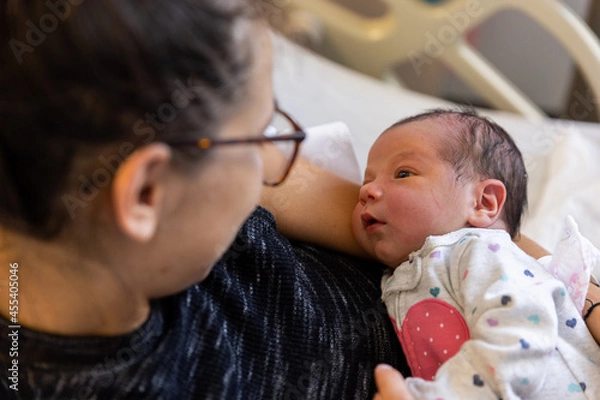 Fototapeta Mother and newborn baby lay in hospital bed - close up