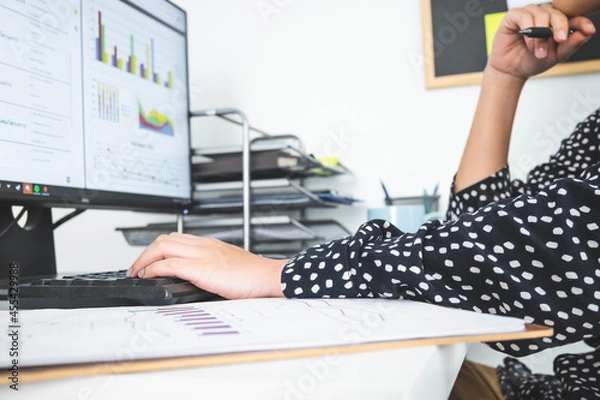 Fototapeta Beautiful young woman in casual clothing using computer and while working indoor.