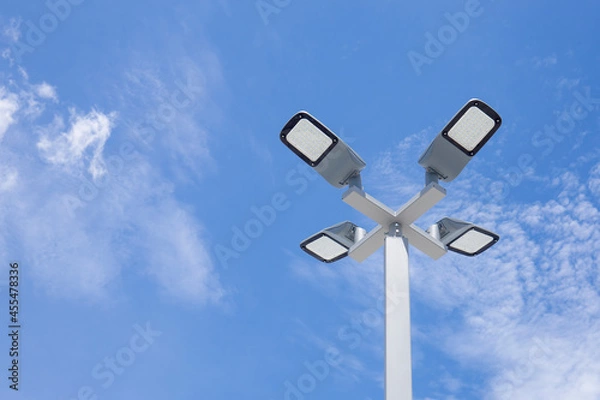 Fototapeta Solar light poles installed outside the building on a bright day sky background.