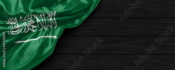 Obraz Close Up of Saudi Arabia flag on the black wooden background 3D render