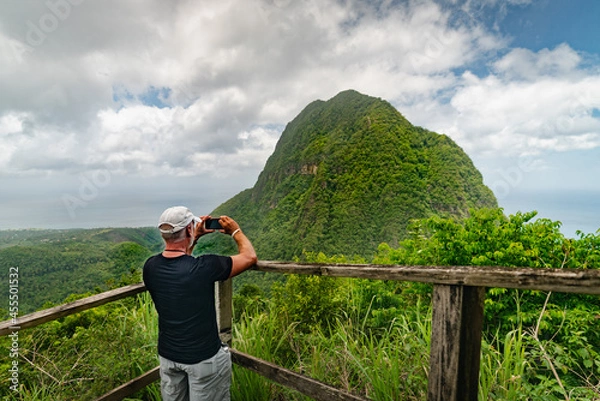 Fototapeta Man taking a photo at a scenic lookout along the Tet Paul Nature Trail in St. Lucia