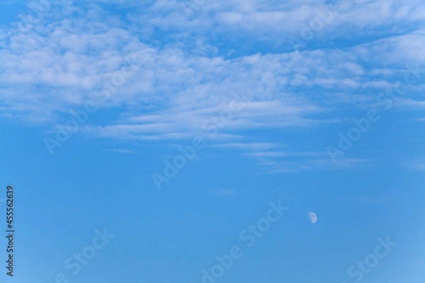Fototapeta Blue sky background with white clouds and the moon