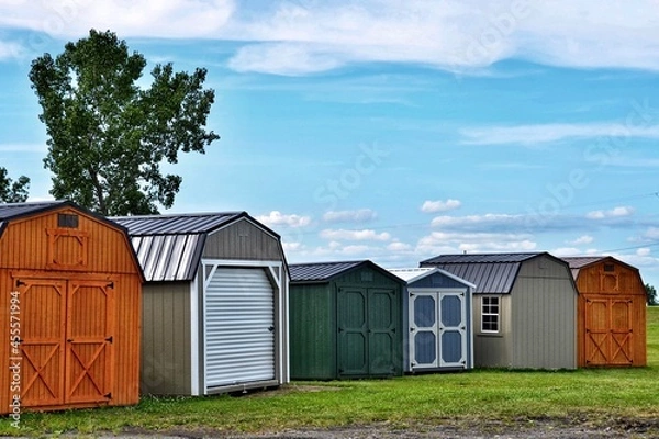 Fototapeta Various styles of wooden sheds on display. American shed is typically a simple, single-story roofed structure in a back garden or on an allotment that is used for storage, hobbies, or as a workshop.