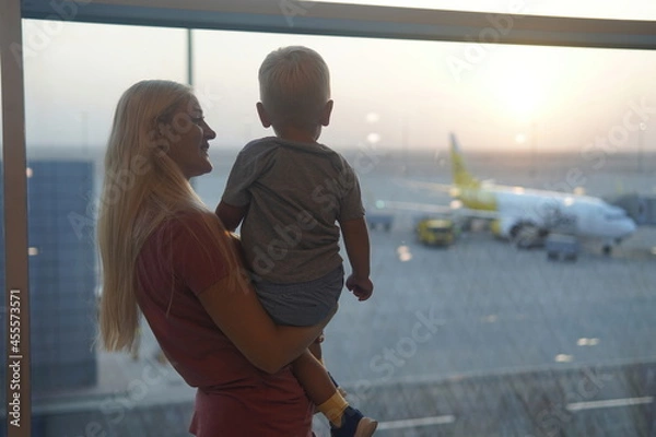 Fototapeta mother and son looking at the plane to the airport. Waiting flight.