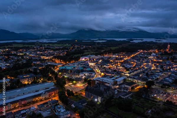 Obraz Aerial view of scenic tourist town of Killarney in county Kerry in Ireland with switched on lights under a cloudy early rise morning cloudy sky