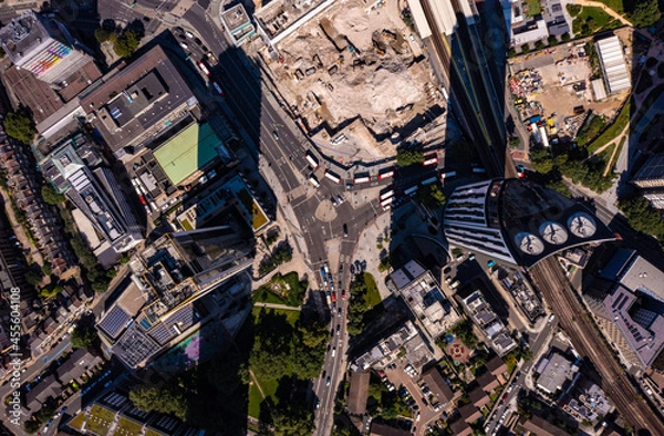 Obraz Birds eye view of tall financial and commercial buildings with shadow and cars moving on city street during a bright sunny day in London city