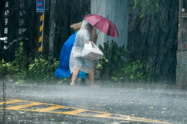 Obraz Pedestrians crossing street during Typhoon Megi