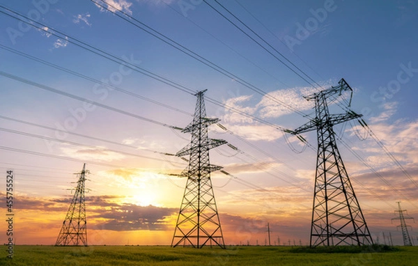 Obraz power line pylons during sunset with beautiful saturated sky. distribution transmission and consumption of electricity