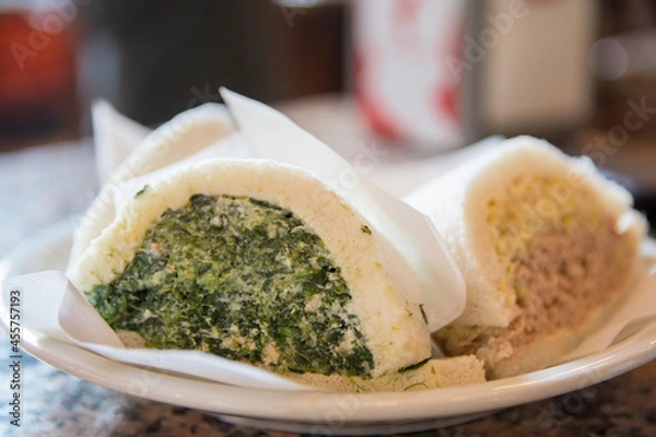 Fototapeta Sliced Tramezzini, triangular Italian sandwiches constructed from two slices of soft white bread, with the crusts removed, containing hard boiled egg and tuna fish, and spinach
