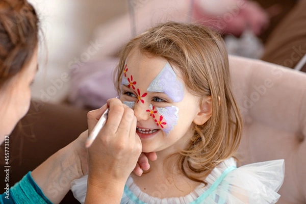 Fototapeta Uśmiechnięte szczęśliwe dziecko z twarzą Art Aqua Grimm na przyjęcie urodzinowe lub Halloween. Malarstwo sztuki twarzy