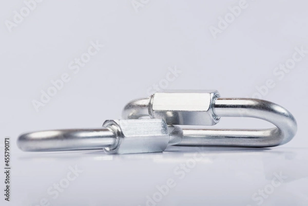 Fototapeta Metal snap hooks on a white isolated background.Spring carabiner made of stainless steel, heavy duty carabiner with quick release lock. 