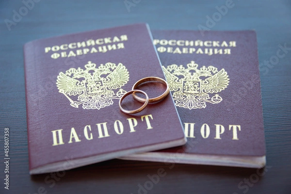 Fototapeta Russian passport and wedding rings. Registration of marriage, filing an application for registration of marriage.