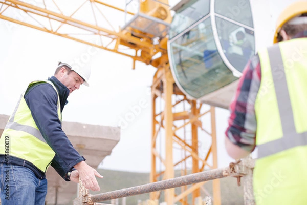 Obraz Constructor workers assembling rebar structure at construction site