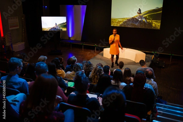 Obraz Female speaker on stage talking to audience
