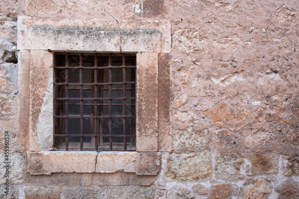 Fototapeta old window with bars, located in a medieval wall