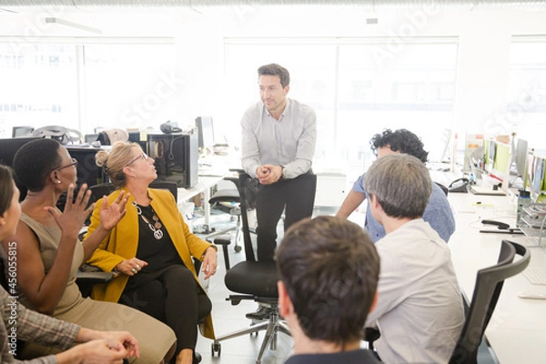 Fototapeta Business people meeting at computer in open plan office