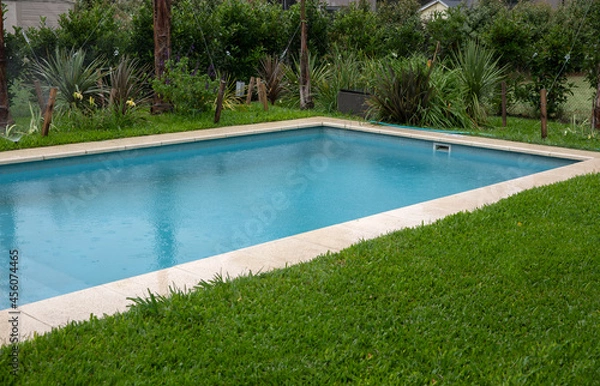 Fototapeta The house rectangular swimming pool and green grass in the backyard. 