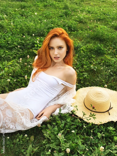 Fototapeta Beautiful young smiling women lying on clover field. Girl enjoying nature. Spring or summer meadow. Grass and flowers
