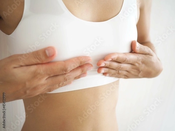 Obraz Small breast problem a woman wearing exercise clothes or white underwear. hands holding on chest. Breast augmentation concept. closeup photo, blurred.
