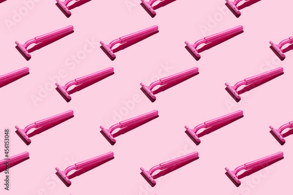 Obraz Pink razors on a pink background, pattern. Hard shadows. The concept of hair removal, body care.