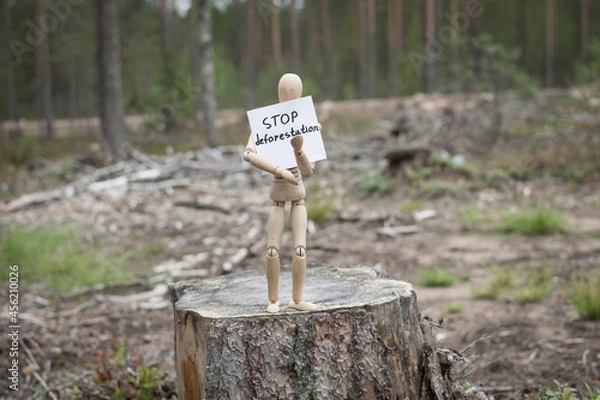 Fototapeta Wooden man on a stump in the forest, deforestation concept.