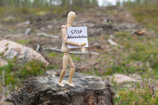 Fototapeta Wooden man on a stump in the forest, deforestation concept.
