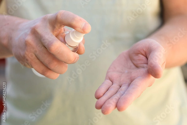 Fototapeta hand disinfection with an antiseptic spray as prevention of coronavirus - Image