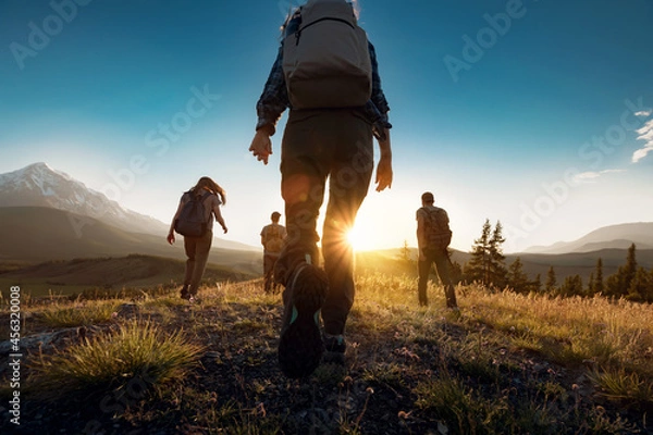 Obraz Group of sporty people walks in mountains at sunset with backpacks. Altai mountains, Siberia, Russia.