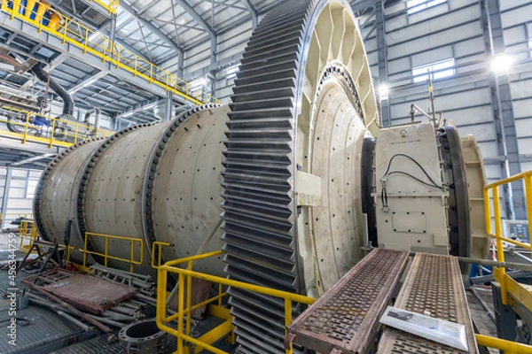 Obraz View of industrial ball mill. A ball mill is a type of grinder used to grind or blend materials for use in mineral dressing processes, paints, pyrotechnics, ceramics, and selective laser sintering.