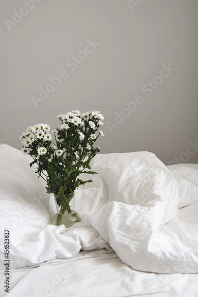 Obraz bouquet of white flowers in bed bedroom with  natural bed sheets blanket 
crumpled