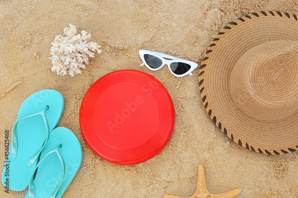 Fototapeta Composition with frisbee disk and beach accessories on sand