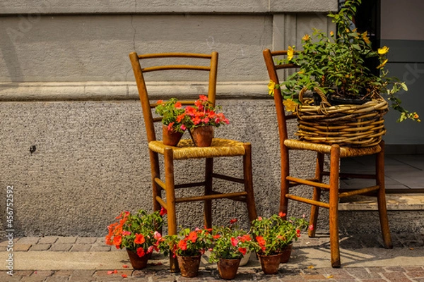 Obraz View of Chairs with Flowers near the Local Store in Como City Center