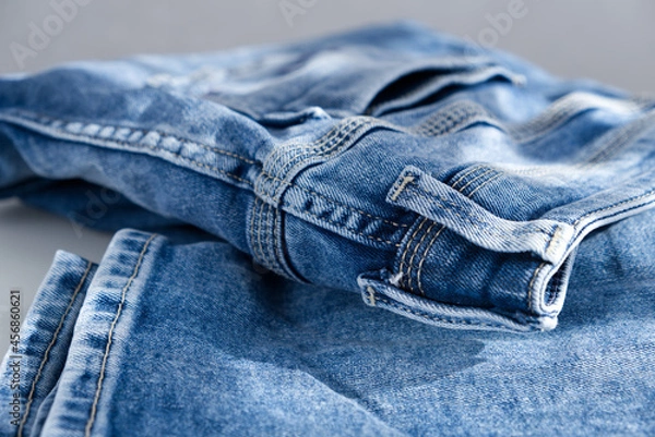Fototapeta a blue light jeans on a grey background. Close up. Sunlight