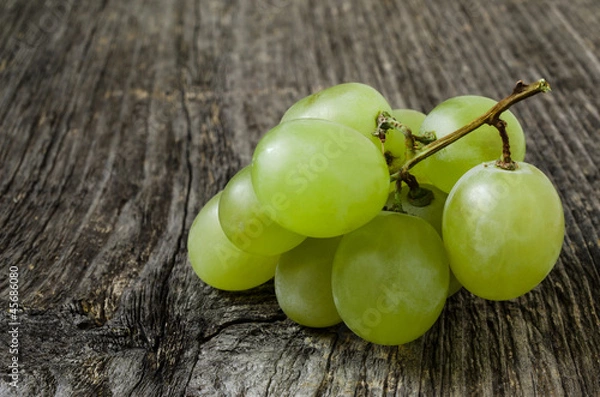 Fototapeta A bunch of green grapes isolated on wood texture