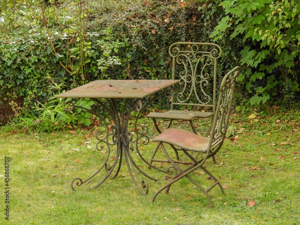 Fototapeta old rusted table and chairs in garden