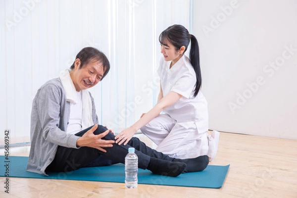 Fototapeta 足が痛い中高年男性と白衣の女性
