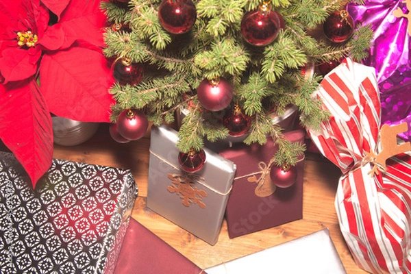 Fototapeta Christmas mood with gifts, on wooden background and tree with red balls