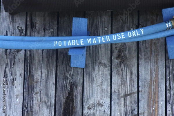 Fototapeta Blue Potable Water Hose on Pier