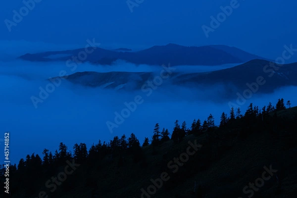 Obraz 夜明け前に周囲が明るくなると雲海から山頂が顔をだした