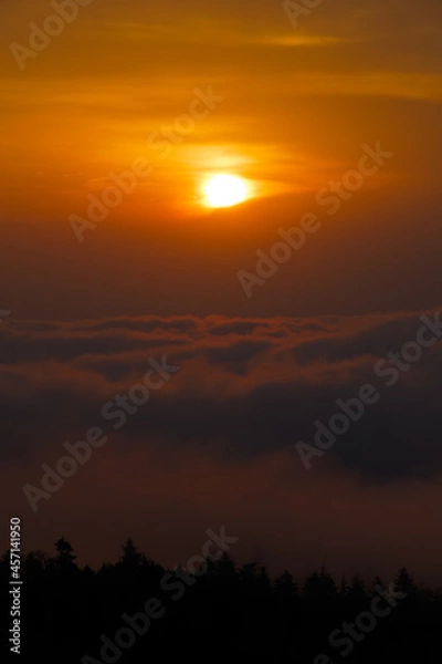 Obraz 雲海の向こうからぼんやりと昇った太陽が雲の切れ間に差し掛かり光出す