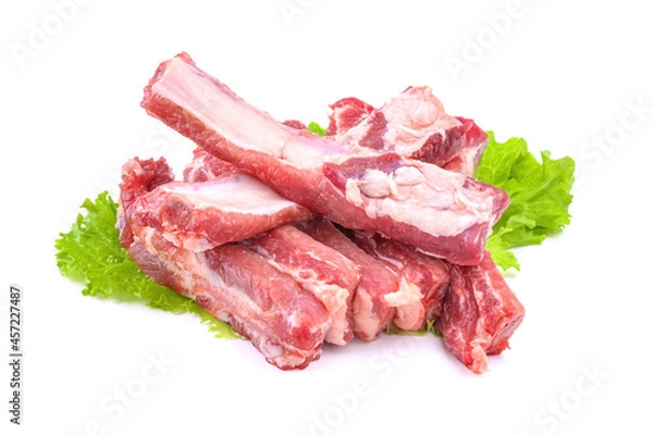 Fototapeta Sliced pork ribs on a lettuce leaf are isolated on a white background.Preparation of meat dishes.