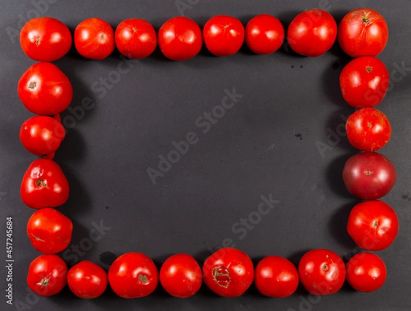 Obraz Rectangular frame of red tomatoes on a black background. Horizontal.