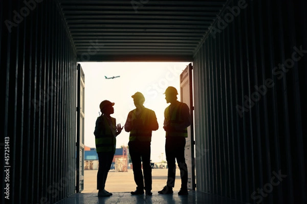Fototapeta silhouette Group of staff worker standing and checking the containers box from cargo ship for export and import