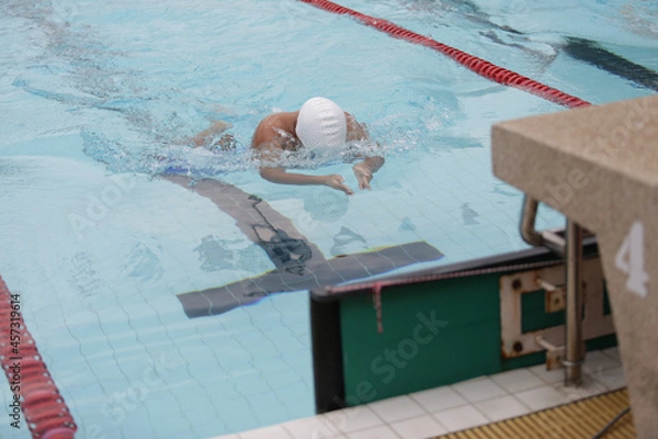 Fototapeta A swimmer competing in a breaststroke is approaching the finish line.