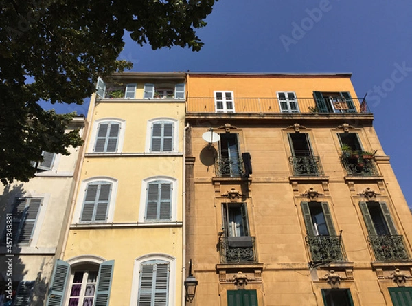 Fototapeta Pastel coloured residential buildings on a calm and friendly street on a summer sunny day in Le Panier - Marseille's oldest and most visited neighborhood.