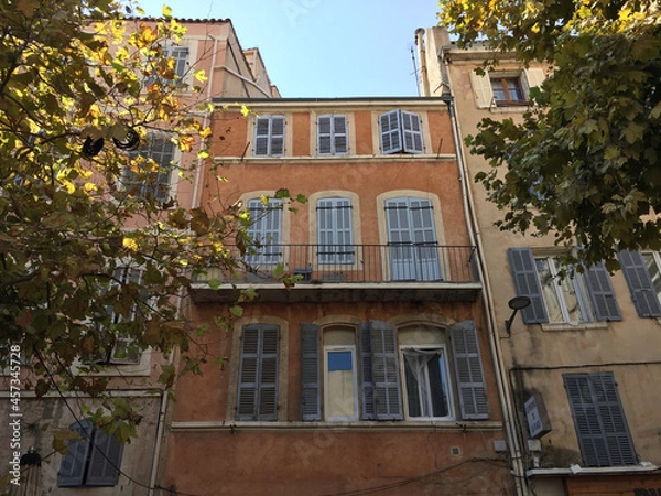 Fototapeta Pastel coloured residential buildings on a calm and friendly street on a summer sunny day in Le Panier - Marseille's oldest and most visited neighborhood.