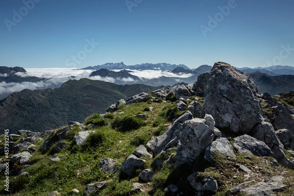 Fototapeta In the background, the Picos de Europa emerge from a sea of ​​clouds.