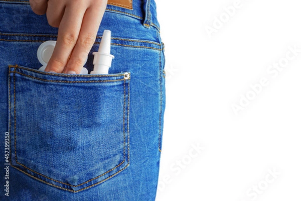 Obraz hand pulls out pills and nasal spray in back pocket of jeans