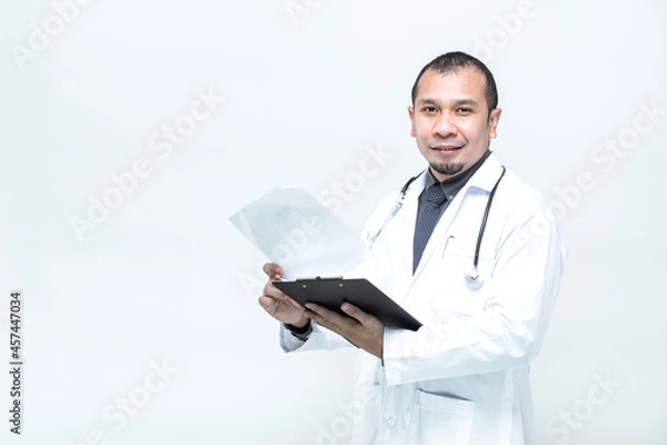 Fototapeta Portrait of cheerful smiling man doctor with stethoscope holding document folder on white background.