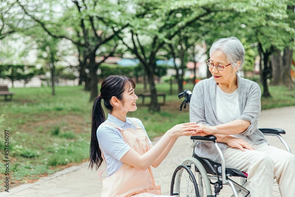 Obraz 車椅子に乗った高齢者女性と女性スタッフ
